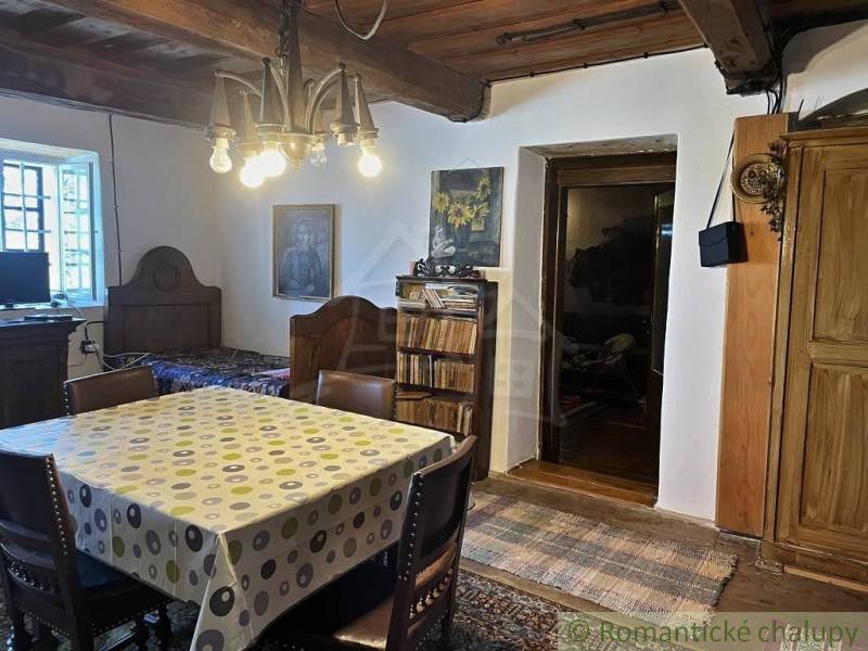 Rustikales Zimmer mit Holzbalkendecke, Esstisch und besonderen Immobilien.