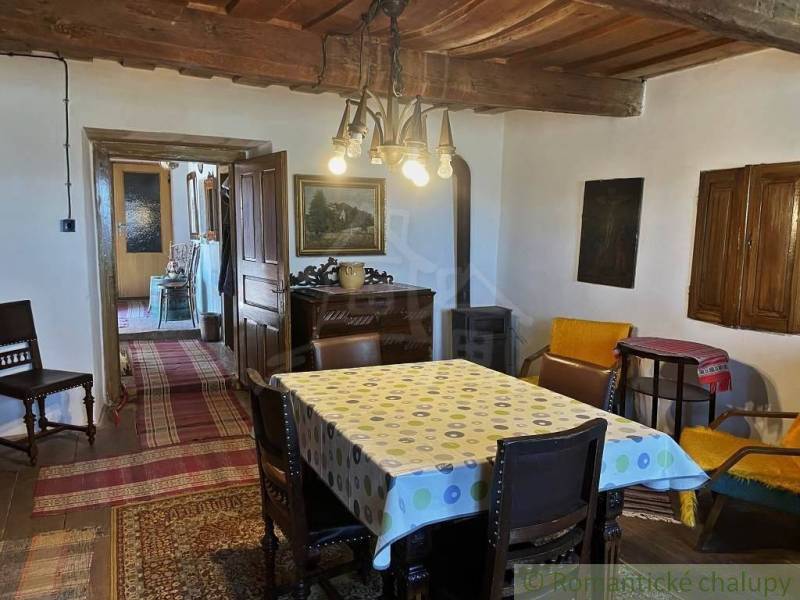 Rustikales Interieur mit Holzbalkendecke, Teppichen und antiken Möbeln. Besondere Immobilien.