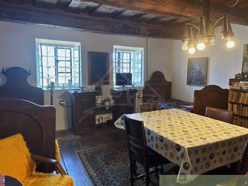 Traditionelles Interieur mit Holzbalken und besonderer Beleuchtung, ergänzt durch antike Möbel.