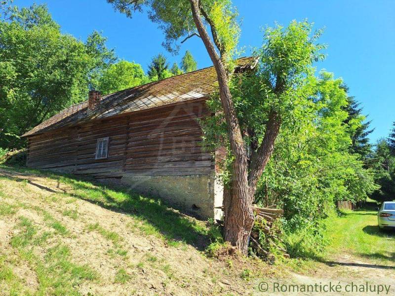 Eine Holzhütte in Liptovský Mikuláš, umgeben von Bäumen und Natur.
