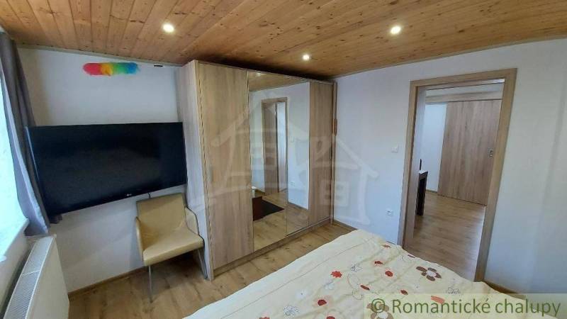 Schlafzimmer mit Holzdecke, Bett und Schränken im Einfamilienhaus.