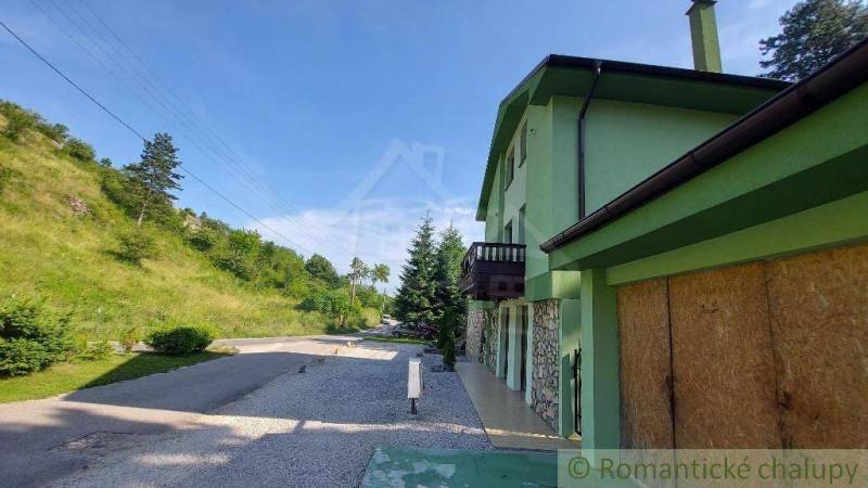 Ein Einfamilienhaus in Dobrá Voda mit einer Straße, umliegender Natur und einer grünen Fassade.