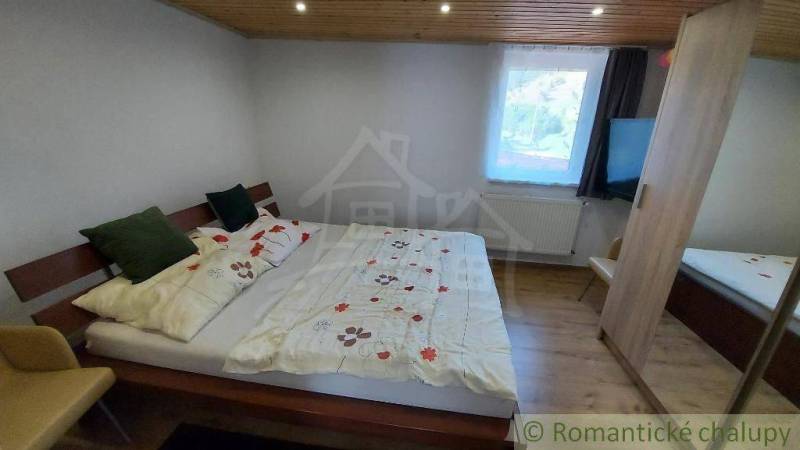 Ein Schlafzimmer in einem Einfamilienhaus mit einem gemütlichen Bett und einer Holzdecke.