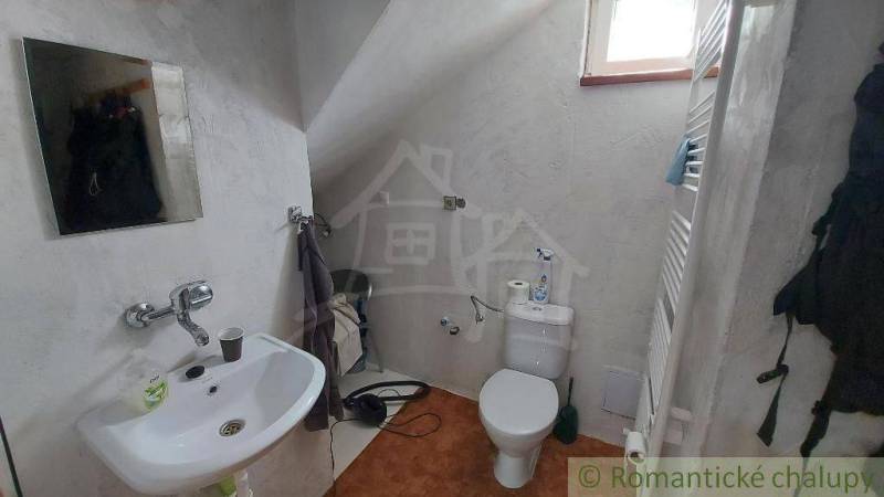 Badezimmer mit Toilette, Waschbecken und Heizkörper im Dachgeschoss eines Einfamilienhauses.