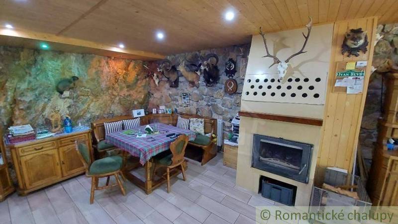 Rustikales Wohnzimmer in einem Einfamilienhaus mit Kamin und Jagddekor.