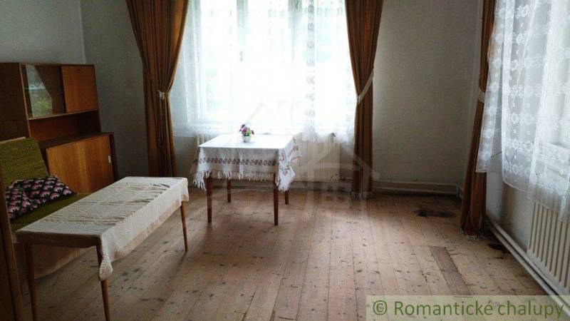 Wohnzimmer eines Einfamilienhauses mit antiken Möbeln und Holzboden.