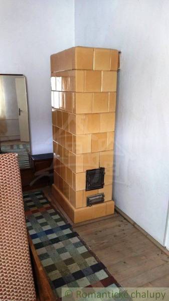 Kachelofen, Holzboden, Spiegel, Teppich im Einfamilienhaus.