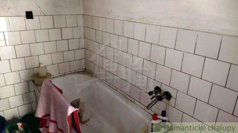 Ein Badezimmer mit einer gefliesten Badewanne in einem Einfamilienhaus.