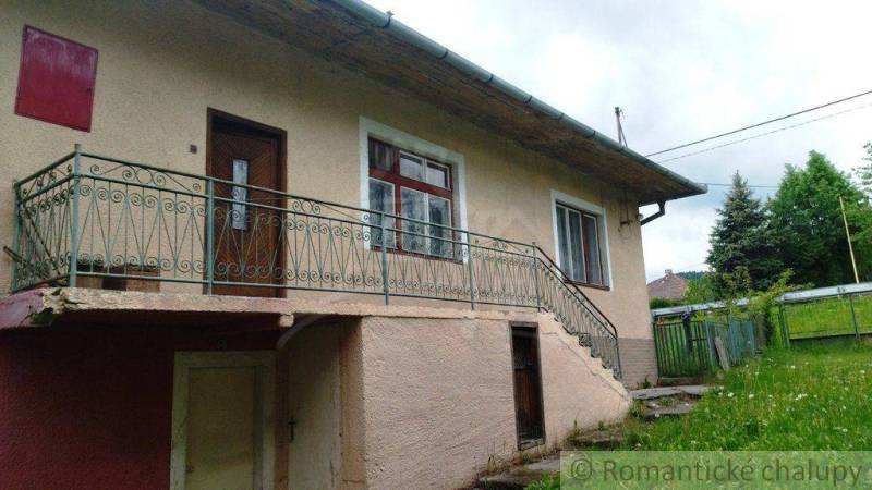 Ein Einfamilienhaus in Fričovce mit Außentreppe und Garten.