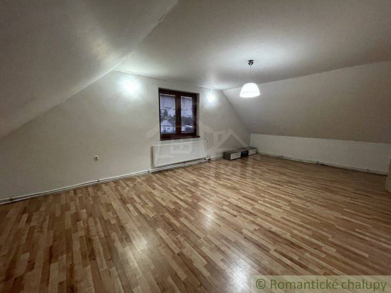 Dachzimmer mit schräger Decke, Beleuchtung und Ausblick, Einfamilienhaus, Holzboden.