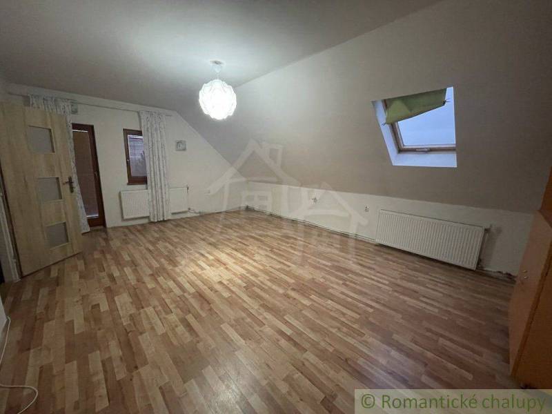 Dachgeschosszimmer in einem Einfamilienhaus mit Laminatboden und Dachfenster.