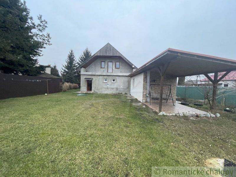 Ein Einfamilienhaus mit Pavillon und Rasen, umgeben von Bäumen, befindet sich in einer ruhigen Gegend.