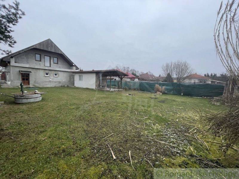 Ein Einfamilienhaus mit Garten und Brunnen in einer ruhigen ländlichen Gegend.