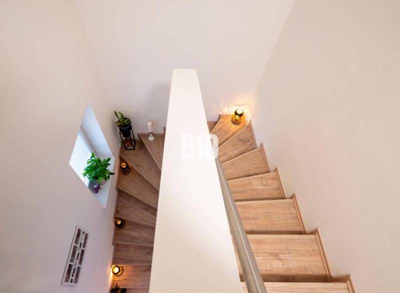 Die Treppe des Einfamilienhauses mit Blumen, Kerzen und Holzstufen.