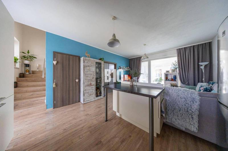 Innenraum eines Einfamilienhauses mit Wohnzimmer, Treppe und Bartresen, helle Holzböden.