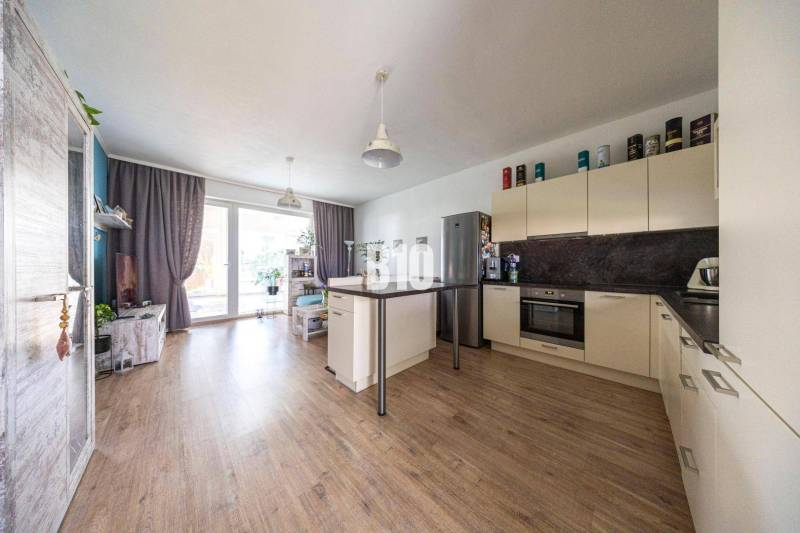Innenraum eines Einfamilienhauses mit heller Küche und Wohnzimmer, Holzboden.