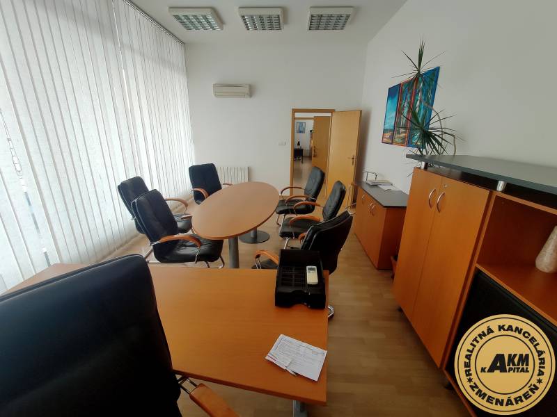Büros ausgestattet mit Möbeln mit rundem Tisch, Sesseln und Schränken.