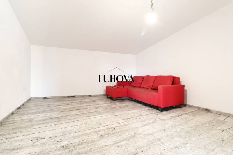 Ein rotes Sofa im Wohnzimmer auf einem Holzboden im Einfamilienhaus.