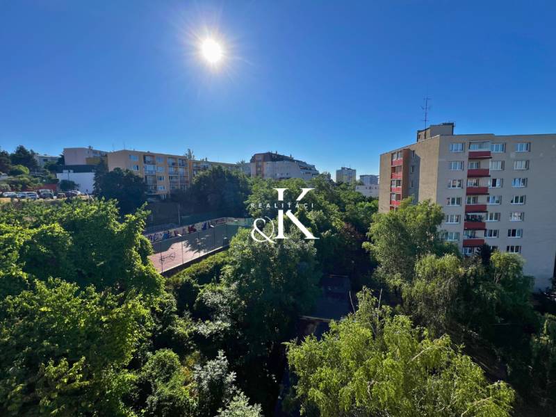 Sonniger Blick auf Grünflächen und Gebäude von einer 2-Zimmer-Wohnung in der Ladzianskeho Straße in Bratislava.