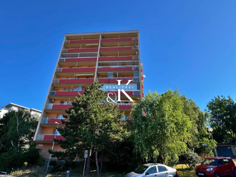 Ein Hochhaus in der Ladzianskeho-Straße, Bratislava - Vinohrady, umgeben von Grünflächen und Autos.