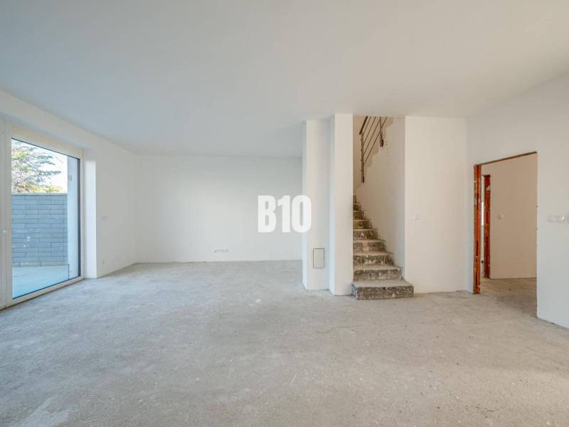 Ein geräumiges Interieur mit einem unfertigen Boden und einer Treppe in einem Einfamilienhaus.