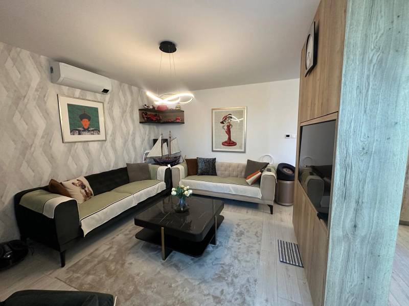 Wohnzimmer in einem Einfamilienhaus mit Sofas, Dekorationen und Bildern an den Wänden.