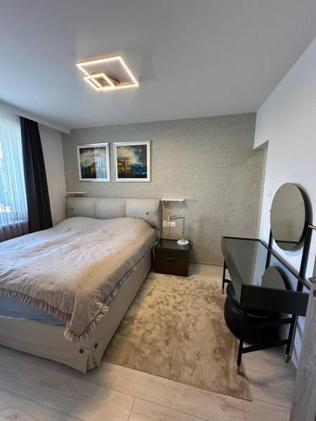 Schlafzimmer in einem Einfamilienhaus mit Bett, Lampe, Tisch und Wanddekoration.