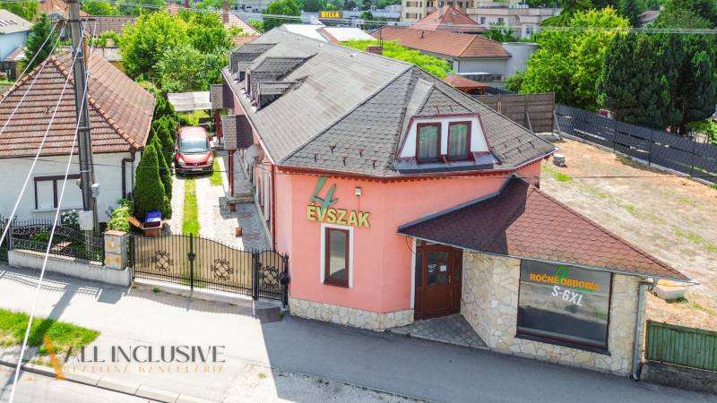 Ein Einfamilienhaus mit Geschäft in der Gyula-Szabó-Straße in Dunajská Streda, umgeben von einem Garten.