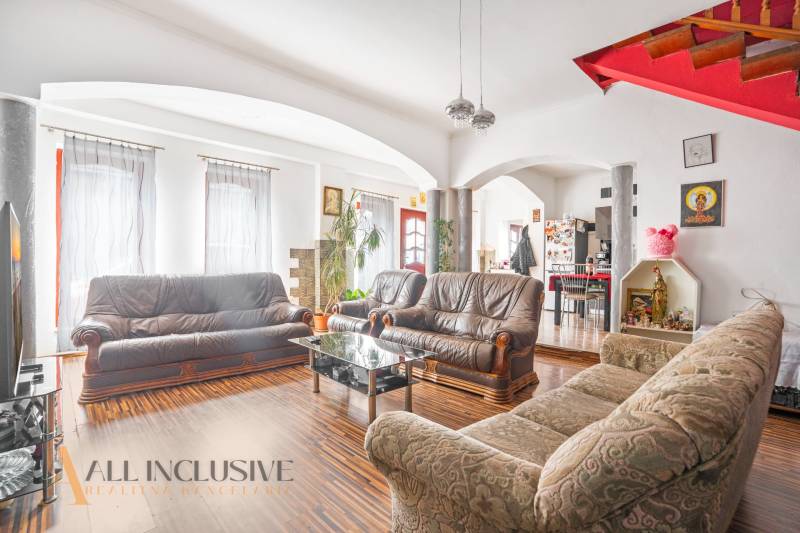 Wohnzimmer mit Ledersofas und Holztreppe in einem Einfamilienhaus.