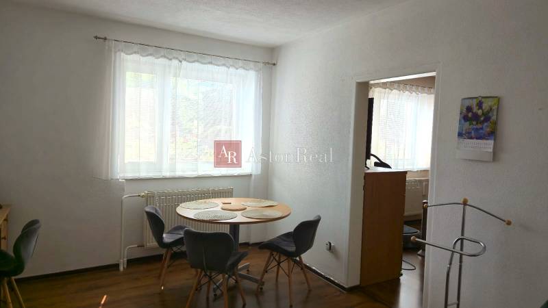 Esszimmer in einem Einfamilienhaus mit Fenster, Tisch und vier Stühlen, weißen Wänden.