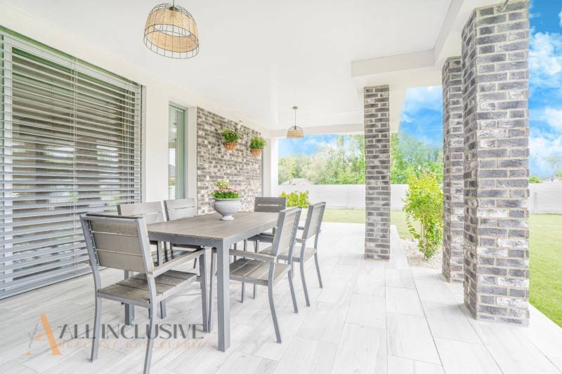 Die Terrasse des Einfamilienhauses in Dunajský Klátov mit Esstisch und Gartenpflanzen.