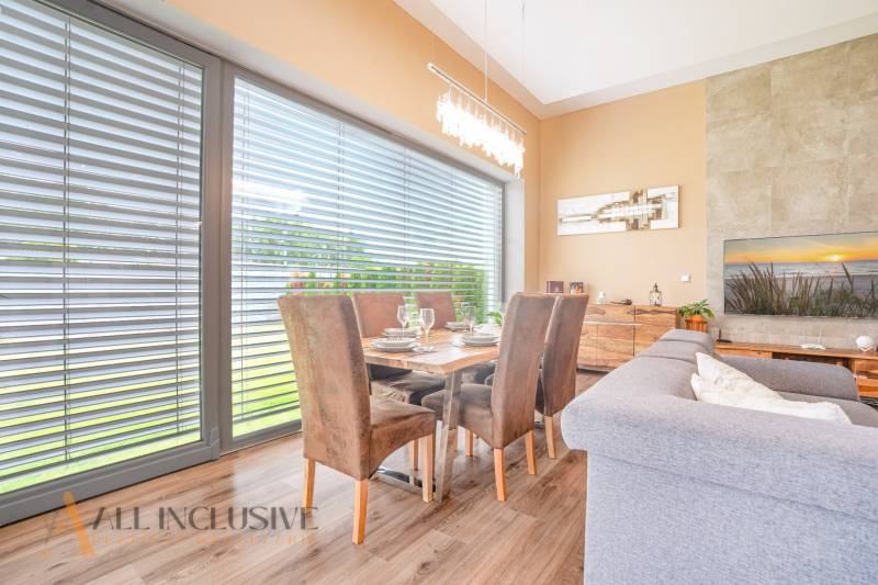 Essbereich in einem Einfamilienhaus mit Holztisch, Stühlen und verdunkeltem Fenster.