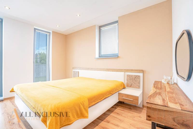 Helles Schlafzimmer mit Holzboden und gelber Decke in einem Einfamilienhaus.