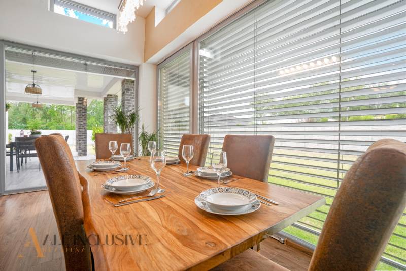 Esszimmer in einem Einfamilienhaus mit einem Holztisch, gedecktem Geschirr und Blick auf die Terrasse.