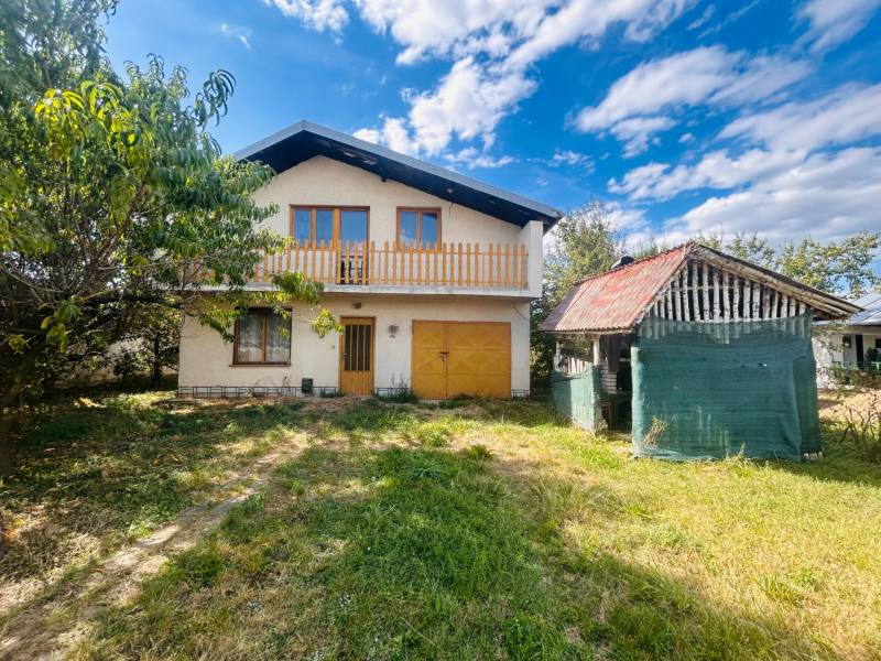 Ein Einfamilienhaus in Sobrance mit Garten und Nebengebäude unter blauem Himmel.