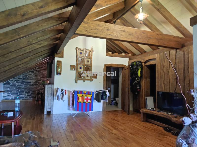 Holzbalken und Holzboden in einer 2-Zimmer-Wohnung mit entspannendem Interieur, Masken an der Wand.