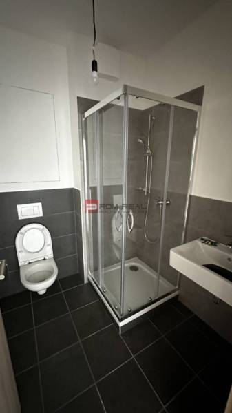 Badezimmer mit Toilette, Dusche und Waschbecken in einer 2-Zimmer-Wohnung.