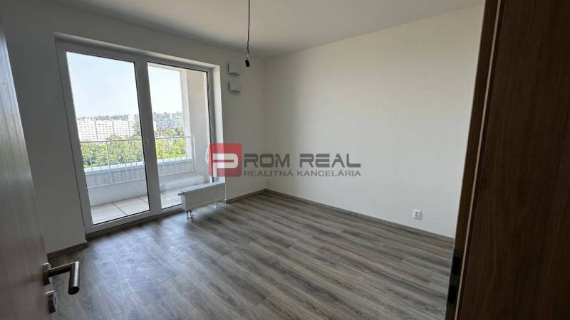Ein leerer Raum mit Laminatboden und Glastüren in einer Zweizimmerwohnung.