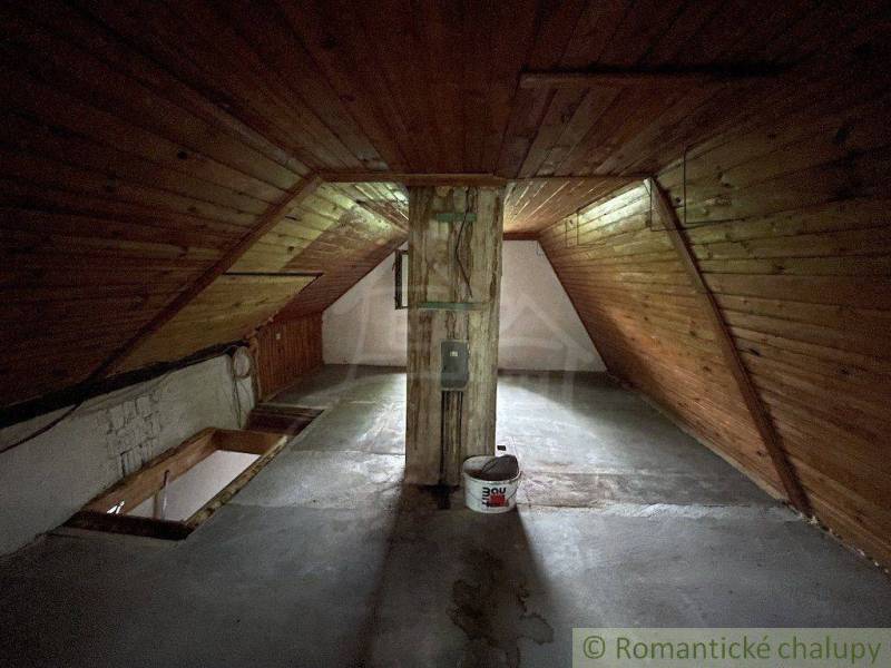 Dachboden mit Holzverkleidung und Betonboden in einem Einfamilienhaus.