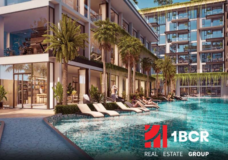Wohnungsbau in Pattaya mit Pool und Liegestühlen, umgeben von Palmen und Pflanzen.