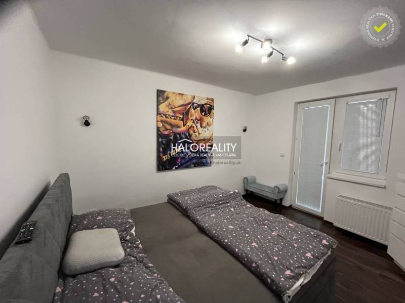 Schlafzimmer mit Bett und Bild, Zugang zum Garten durch das Fenster, Einfamilienhaus.