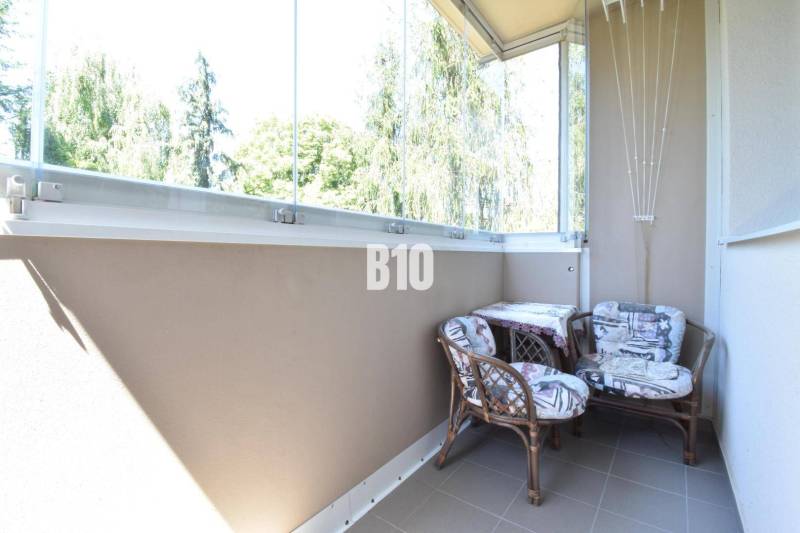 Ein verglaster Balkon mit zwei Stühlen in einer 3-Zimmer-Wohnung mit schönem Ausblick.