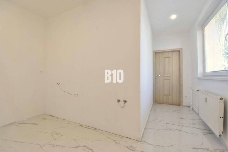 Weiße Wand und Fliesenboden in einer 3-Zimmer-Wohnung, leeres Zimmer.