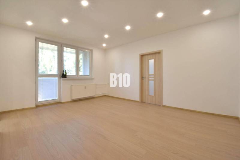 Wohnzimmer mit Parkettboden und weißen Wänden in einer 3-Zimmer-Wohnung.