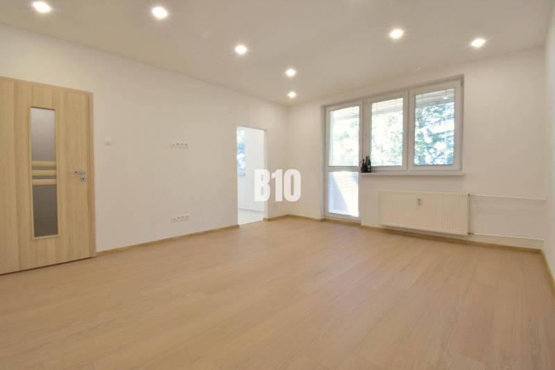 Helles Zimmer in einer 3-Zimmer-Wohnung mit Holzboden und großem Fenster.