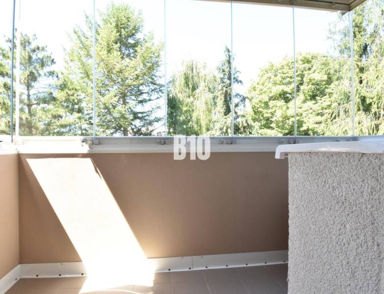 Ein verglaster Balkon mit Blick auf das Grün bei einer 3-Zimmer-Wohnung in Bytča.