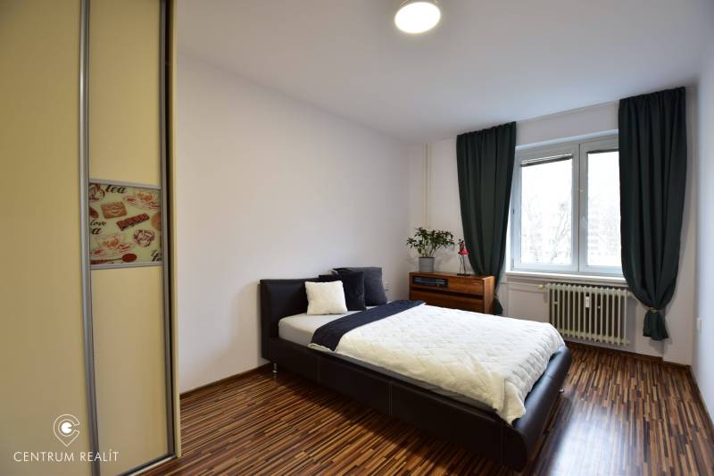 Schlafzimmer in einer 2-Zimmer-Wohnung mit Bett, Einbauschrank und Fenster.