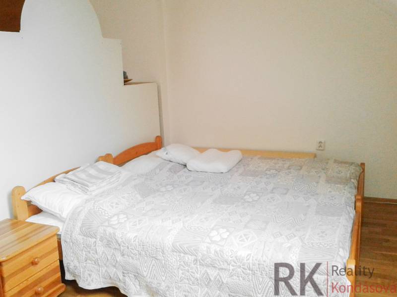 Helles Schlafzimmer mit Doppelbett in einer 2-Zimmer-Wohnung.