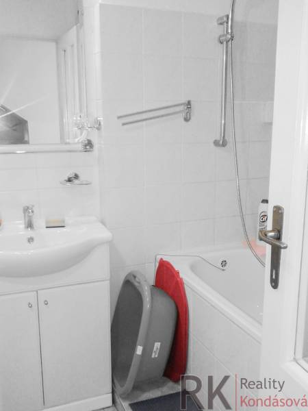 Badezimmer in einer 2-Zimmer-Wohnung mit Badewanne und Waschbecken, weiße Fliesen.