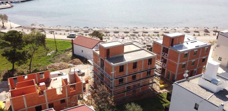 Bauarbeiten am Strand in der Stadt Vir, mit im Bau befindlichen Gebäuden in der Nähe der Küste.